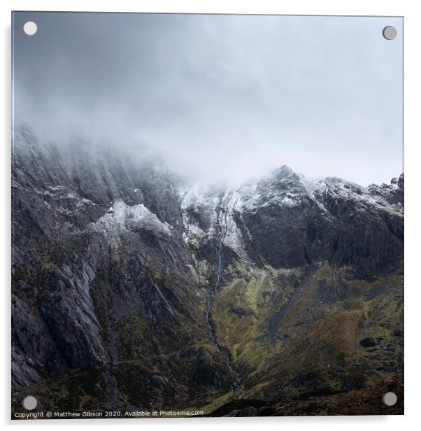 Stunning dramatic landscape image of snowcapped Glyders mountain range in Snowdonia during Winter with menacing low clouds hanging at the peaks Acrylic by Matthew Gibson