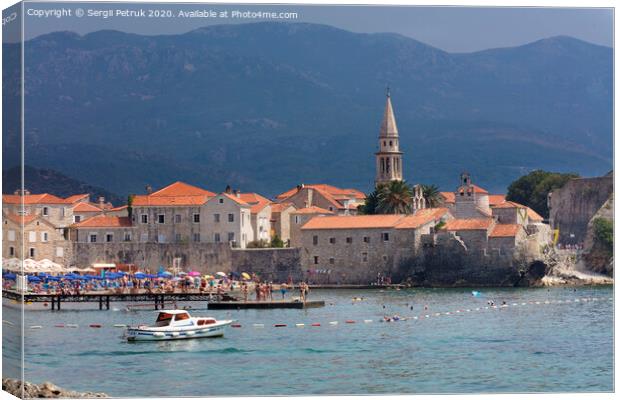 View of the beach and the old town of Budva in Montenegro against the background of blue-green mountains. August 2018. Canvas Print by Sergii Petruk