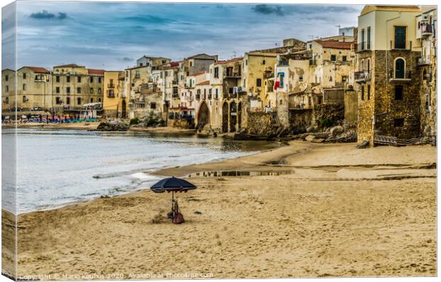 Beach with umbrella in the city of cefalu Canvas Print by Mario Koufios
