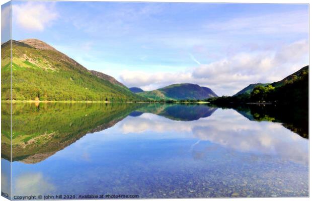 Reflections in Buttermere lake with Mellbreak mountain in Cumbria.  Canvas Print by john hill