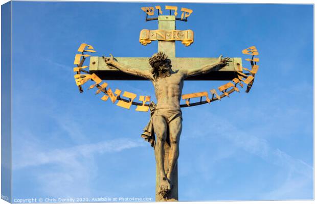 Crucifix on the Chales Bridge in Prague Canvas Print by Chris Dorney