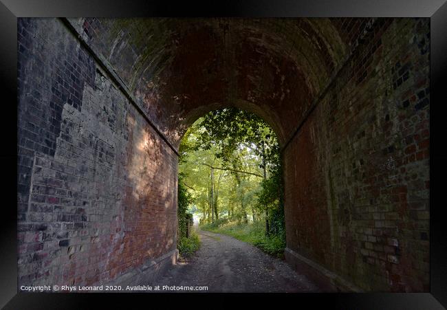 Red brick tunnel contains a muddy double-track lane Framed Print by Rhys Leonard