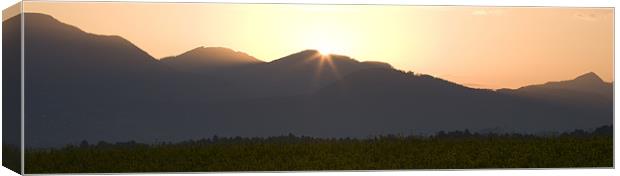 Sunrise bursting over the kamnik alps and rapeseed Canvas Print by Ian Middleton