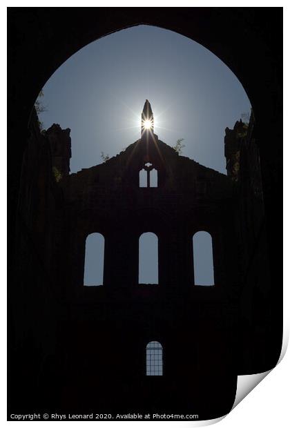 Sun flares through opening in the peak of a ruined wall of kirkstall abbey Print by Rhys Leonard