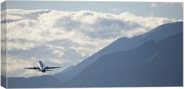 Airplane taking off over the alpine mountains Canvas Print by Ian Middleton
