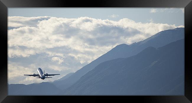 Airplane taking off over the alpine mountains Framed Print by Ian Middleton
