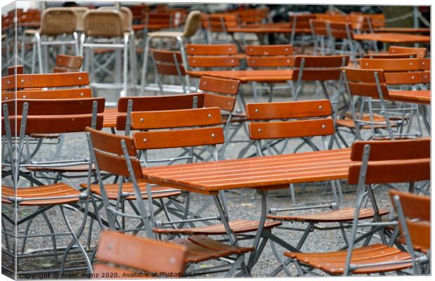 Unoccupied chairs and tables in a garden restaurant  Canvas Print by Frank Heinz