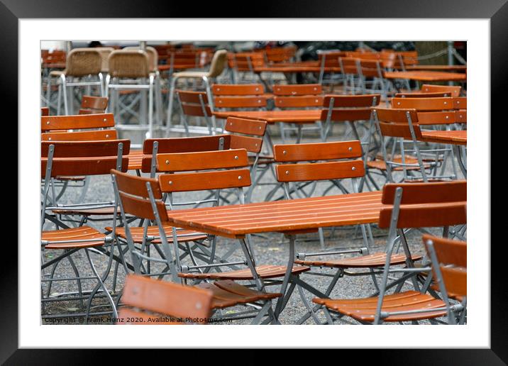 Unoccupied chairs and tables in a garden restaurant  Framed Mounted Print by Frank Heinz
