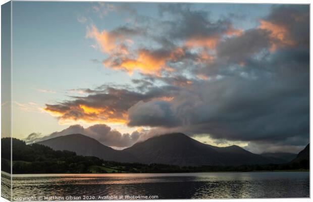 Beautiful sunrise landscape image looking across Loweswater in the Lake District towards Low Fell and Grasmere with vibrant sunrise sky breaking on the mountain peaks Canvas Print by Matthew Gibson
