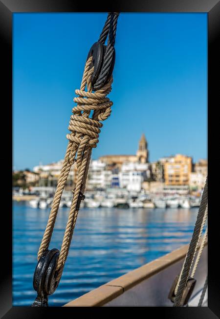 Small Spanish town in Costa Brava, Palamos.Foreground a sail boat rigging. Framed Print by Arpad Radoczy