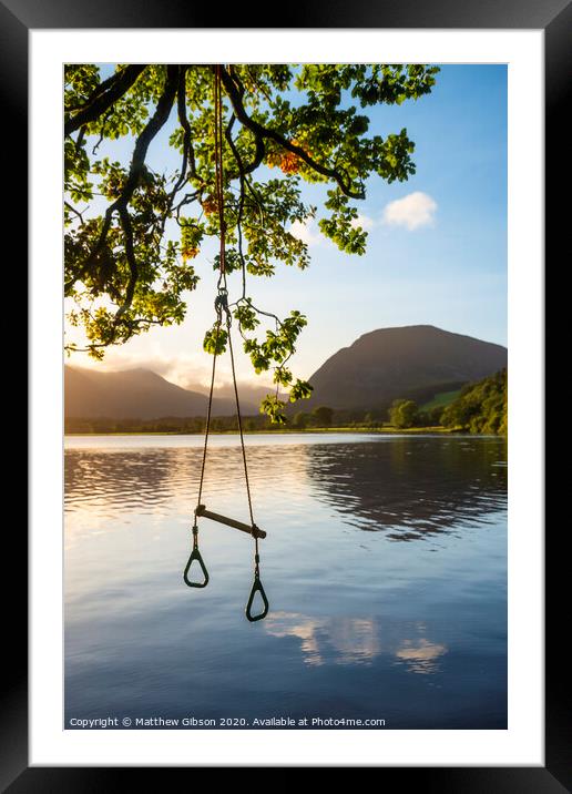 Quintessential beautiful English Summer landscape image of child's rope swing over calm lake in Lake District during golden Summer sunrise Framed Mounted Print by Matthew Gibson