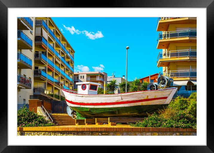 view of the promenade in the seaside town, in the middle of the roundabout old fishing boat Framed Mounted Print by Q77 photo