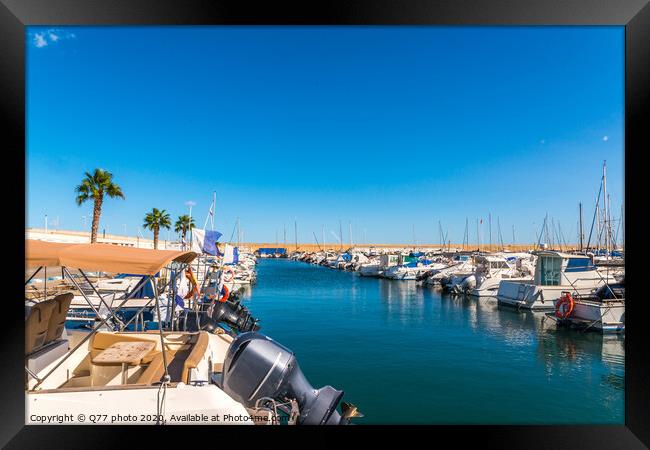 Beautiful luxury yachts and motor boats anchored in the harbor, hot summer day and blue water in the marina, blue sky Framed Print by Q77 photo