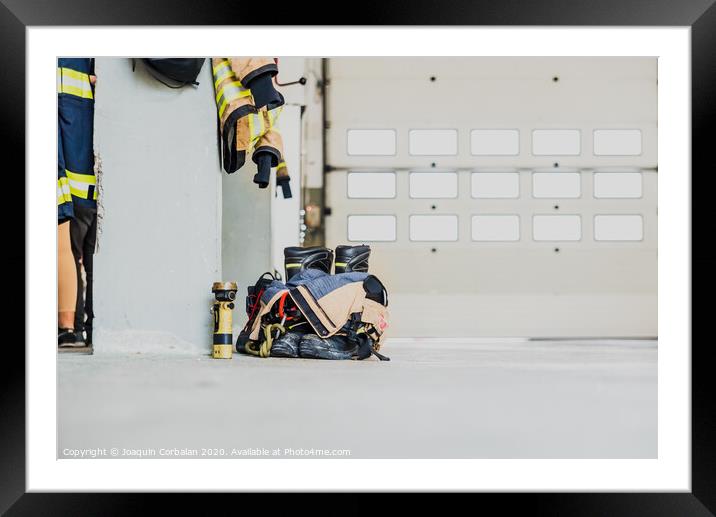 Detail of the work suit of a firefighter prepared for action next to the material to extinguish fires safely. Framed Mounted Print by Joaquin Corbalan