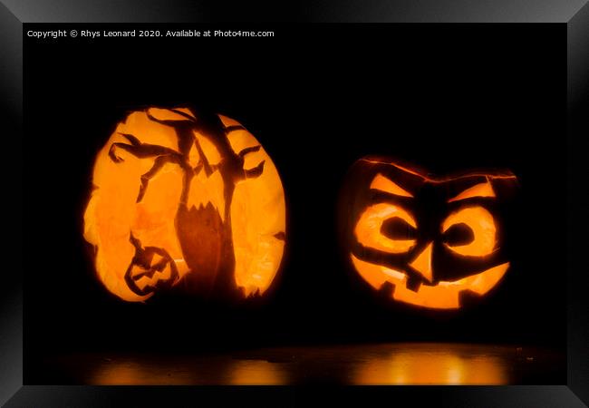 Two intricately carved halloween pumpkins lit by candle tea lights Framed Print by Rhys Leonard