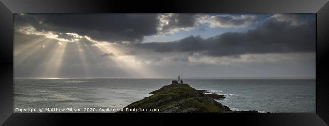 Landscape panorama of Mumbles lighthouse in Wales with sunbeams over sea Framed Print by Matthew Gibson