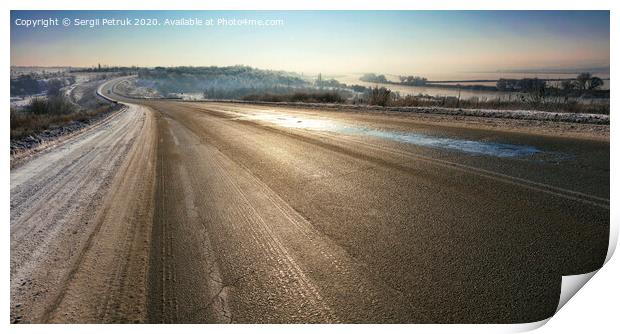 An old asphalt road is illuminated by sunshine in the winter morning. Print by Sergii Petruk