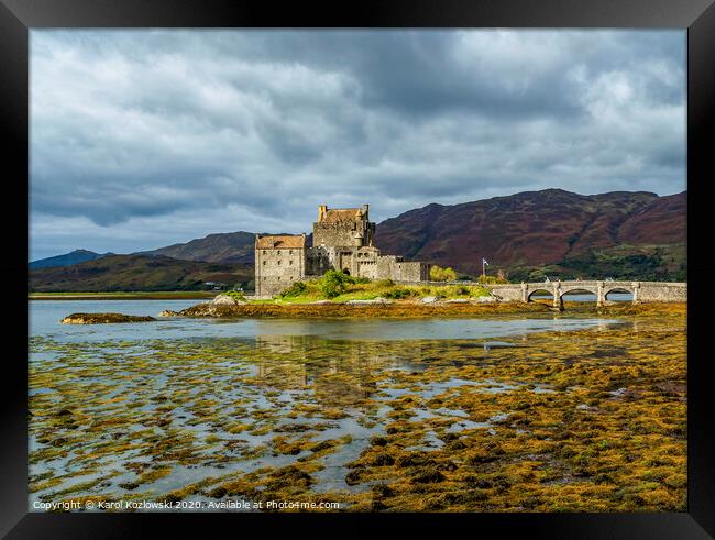 A body of water with Eilean Donan in the background Framed Print by Karol Kozlowski