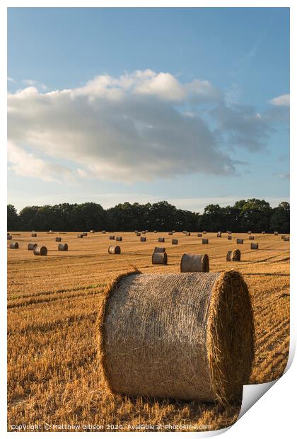 Beautiful countryside landscape image of hay bales in Summer field during colorful sunset Print by Matthew Gibson