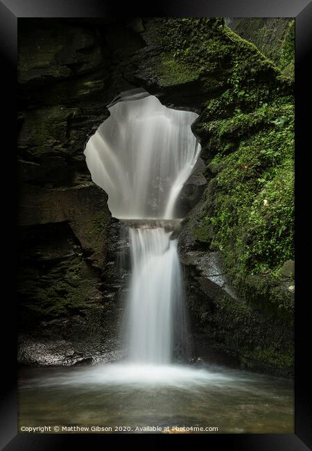 Beautiful flowing waterfall with magical fairytale feel in lush green forest location Framed Print by Matthew Gibson