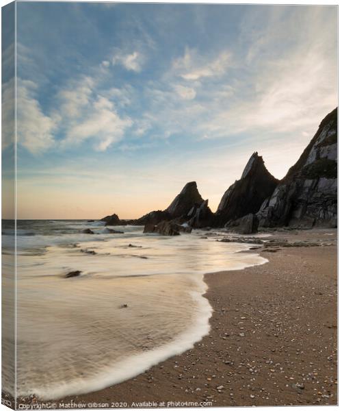 Stunning sunset landscape image of Westcombe Beach in Devon England with jagged rocks on beach and stunning cloud formations Canvas Print by Matthew Gibson