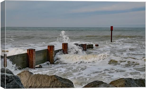 Waves crashing over the wooden groynes at high tide on Cart Gap beach Canvas Print by Chris Yaxley