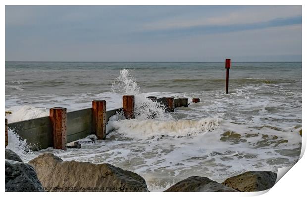 Waves crashing over the wooden groynes at high tide on Cart Gap beach Print by Chris Yaxley