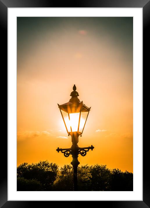 the setting sun behind a street light in Knaresborough Framed Mounted Print by mike morley