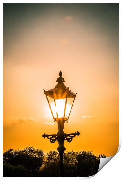 the setting sun behind a street light in Knaresborough Print by mike morley