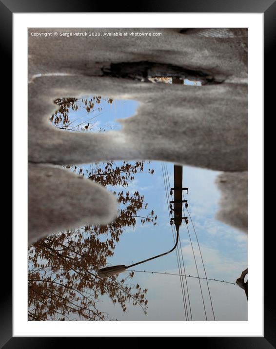 Reflection of the sky, the silhouette of a street lamp and a tree in a puddle on bad asphalt. Framed Mounted Print by Sergii Petruk