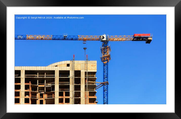 Facade and construction crane near the modern concrete building under construction. Framed Mounted Print by Sergii Petruk