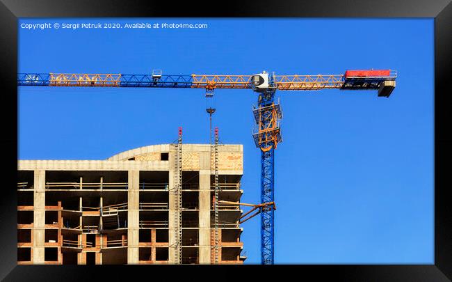 Facade and construction crane near the modern concrete building under construction. Framed Print by Sergii Petruk