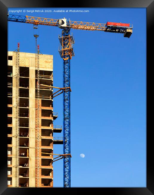 Facade and construction crane near the modern concrete building under construction. Framed Print by Sergii Petruk