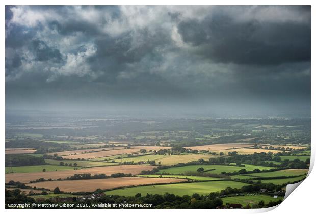 Stunning Summer landscape image of escarpment with dramatic storm clouds and sun beams streaming down Print by Matthew Gibson