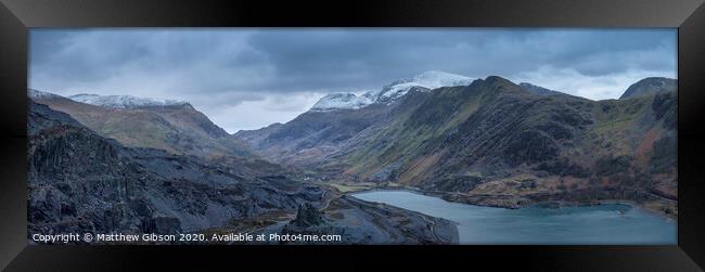 Beautiful landscape image of Dinorwig Slate Mine and snowcapped Snowdon mountain in background during Winter in Snowdonia with Llyn Peris in foreground Framed Print by Matthew Gibson