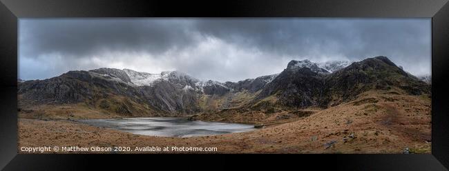 Beautiful moody Winter landscape image of Llyn Idwal and snowcapped Glyders Mountain Range in Snowdonia Framed Print by Matthew Gibson
