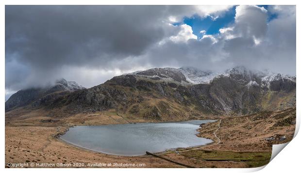 Beautiful moody Winter landscape image of Llyn Idwal and snowcapped Glyders Mountain Range in Snowdonia Print by Matthew Gibson
