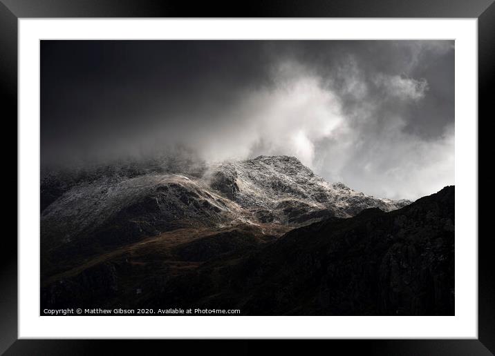 Stunning moody dramatic Winter landscape image of snowcapped Tryfan mountain in Snowdonia with stormy weather brooding overhead Framed Mounted Print by Matthew Gibson