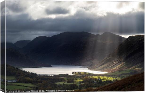 Majestic sun beams light up Crummock Water in epic Autumn Fall landscape image with Mellbreak and Grasmoor  Canvas Print by Matthew Gibson