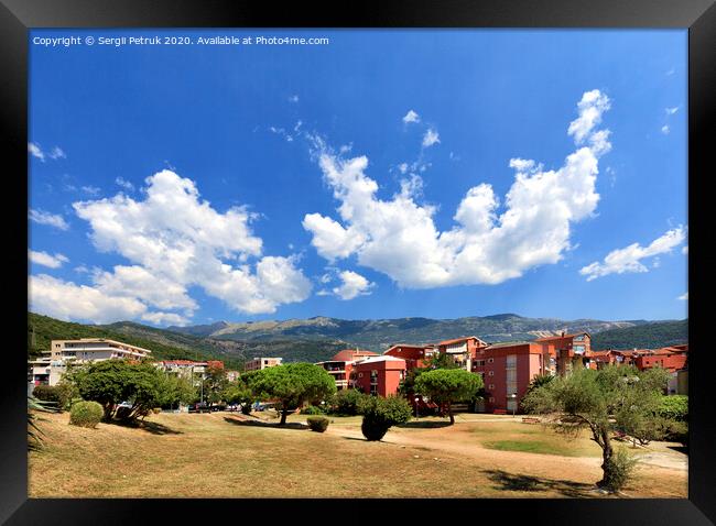 In the colorful urban valley of Montenegro white clouds float across the sky. Framed Print by Sergii Petruk