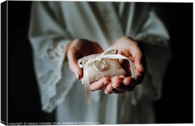Wedding rings on a pad held by the delicate hands of a bride. Canvas Print by Joaquin Corbalan