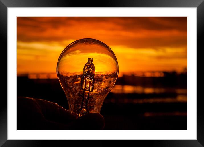 Light bulb in hand against colorful sunrise  Framed Mounted Print by Miro V