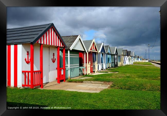 Stormy skies over beach huts in Lincolnshire. Framed Print by john hill