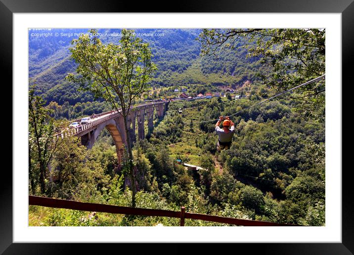 A tourist crosses over a long cable car over a mountain and a forest across the Tiara River. Framed Mounted Print by Sergii Petruk