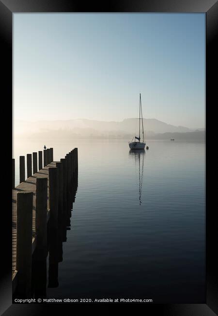 Stunning unplugged fine art landscape image of sailing yacht sitting still in calm lake water in Lake District during peaceful misty Autumn Fall sunrise Framed Print by Matthew Gibson