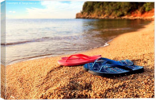 Beach slippers lie on a stone near the transparent sea Canvas Print by Sergii Petruk