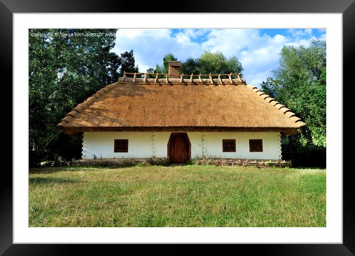 Old traditional Ukrainian rural house with thatched roof and wicker fence in the garden Framed Mounted Print by Sergii Petruk