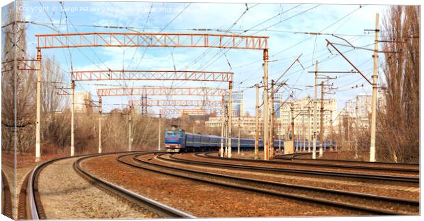Passenger train cars of the train ride on the railway tracks in the background of the cityscape Canvas Print by Sergii Petruk