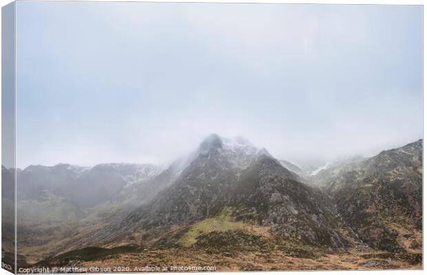 Stunning moody dramatic Winter landscape image of snowcapped Y Garn mountain in Snowdonia Canvas Print by Matthew Gibson