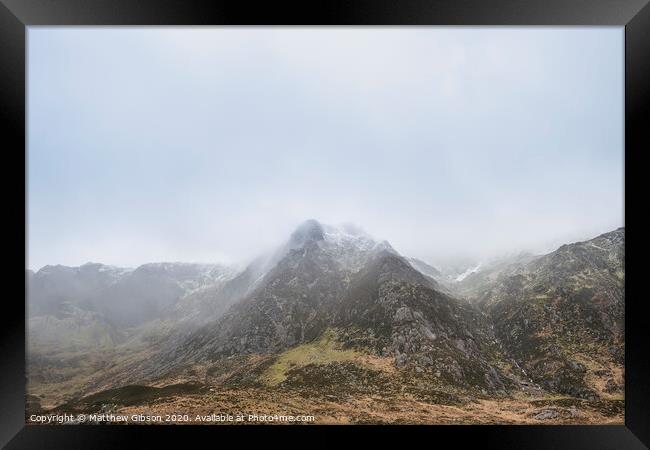 Stunning moody dramatic Winter landscape image of snowcapped Y Garn mountain in Snowdonia Framed Print by Matthew Gibson